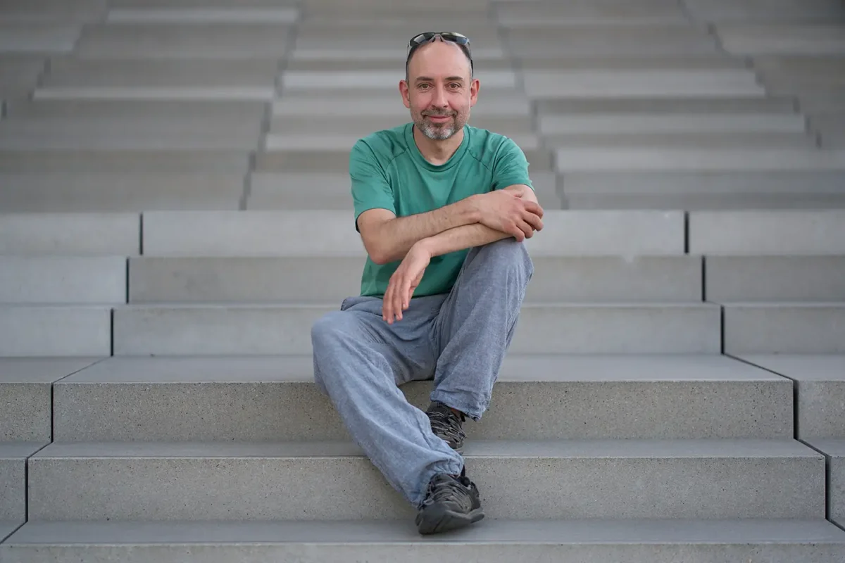 Authentisches Selbstporträt: Businessfotograf Stefan Schubert auf einer Treppe in Berlin; Stefan Schubert Fotografie“