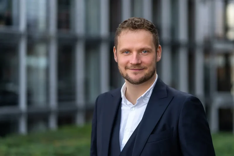 Businessportrait in Berlin-Mitte: Ein junger Mann im modernen Business-Outfit beim Outdoor-Shooting - Stefan Schubert.