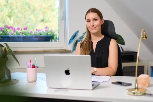 Authentisches Business-Porträt einer Unternehmerin am Laptop im hellen Büro – Corporate Fotografie von Stefan Schubert.