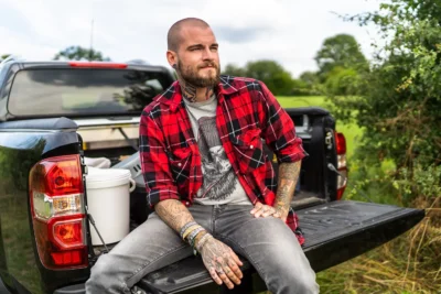 Markante Aufnahme eines tätowierten Mannes auf der Ladefläche eines Pick-ups; Charakter-Bild von Stefan Schubert.