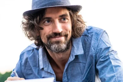 Ausdrucksstarke Nahaufnahme eines Künstlers mit strahlendem Blick; Signature Look; Portraitfotografie Stefan Schubert.