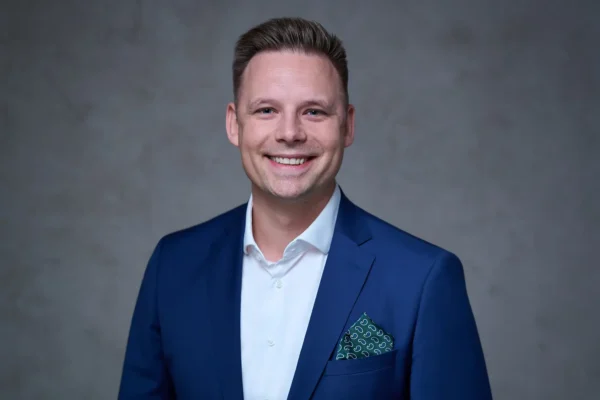 Office-Shooting: Mitarbeiter im klassischen Business-Outfit vor dunklem Hintergrund, Stefan Schubert Fotografie Berlin.