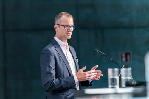 Start-up-Gründer spricht am Rednerpult vor Publikum; Eventfotografie Stefan Schubert.