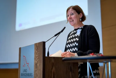 Katrin Müller-Wartig (MIL Brandenburg) spricht am Rednerpult in der Staatskanzlei Potsdam; Eventfotografie Stefan Schubert.