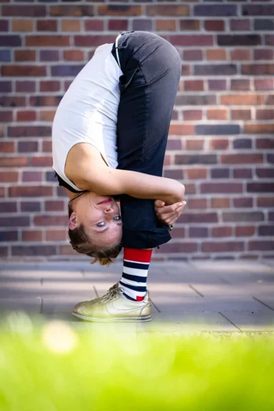 Schauspielerin beweist Beweglichkeit am Set durch stehende Rumpfbeuge; Sedcard-Fotografie Stefan Schubert.