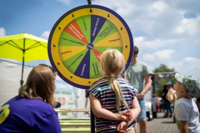 Spielerische Berufsorientierung: Kinder am Glücksrad der Brandenburg-will-dich-Kampagne; PR Referenz von Stefan Schubert