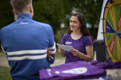 Kampagnen-Mitarbeiterin mit Jugend am Info-Stand mit Glücksrad; Brandenburg Will Dich; Fotografiert von Stefan Schubert